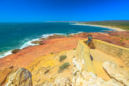 Travel photographer with stabilizer takes shot at Red Bluff lookout, Kalbarri National Park, Western Australia. Professional videomaker takes photo of Australian Coral Coast on Indian Ocean.Copy space