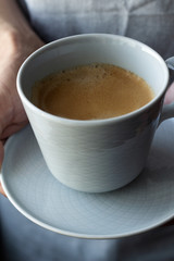 cup of black coffee on a gray background close-up.