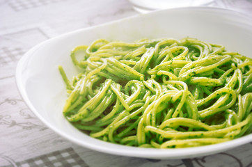 A plate of spaghetti with pesto sauce