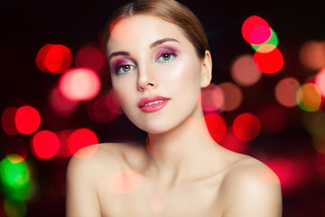 Young happy woman with makeup on sparkle bokeh