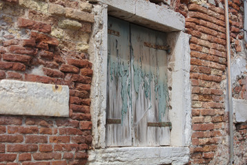 Fototapeta na wymiar Old window shutter surrounded by brick wall 4855