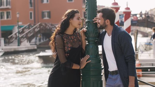 Beautiful couple in Venice, Italy - Lovers on a romantic date and kissing in Venice, Italy. Beautiful woman, handsome man in slow motion 4K UHD footage