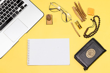 Fototapeta na wymiar quran, laptop, notebook, stamp, glasses and siwak on yallow background