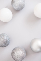 White Christmas background. Glossy silver and glitter decoration balls. Minimalist style. Copyspace for text, overhead
