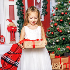 A little girl opens a gift box. Concept New Year, Merry Christma