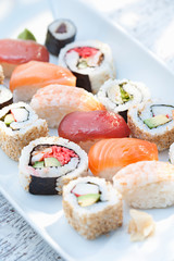 Sushi and assorted Japanese food on white plate.