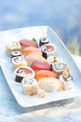 Sushi and assorted Japanese food on white plate.