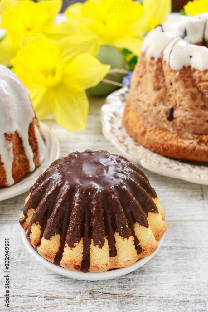 Wall mural Traditional easter cakes and bouquet of daffodils in the background.