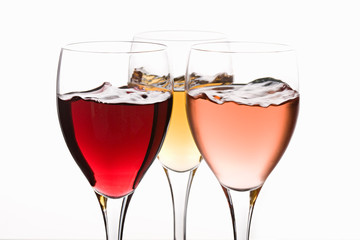 Red, white and rose wines, swirling in glasses.