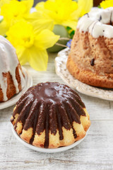 Traditional easter cakes and bouquet of daffodils in the background.