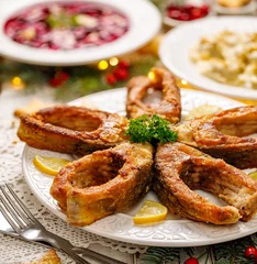 Crédence de cuisine en verre imprimé Plats de repas Fried carp fish slices on a white plate, close up. Traditional christmas eve dish. Polish Christmas food