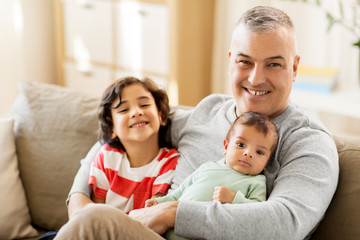 Obraz premium family, fatherhood and people concept - happy father with preteen and baby son at home