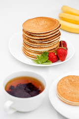 Homemade pancakes with fresh strawberries and honey.