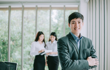 Smiling Businessman on the background of business people working  in office.
