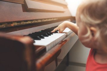 music education - child pushing piano keys