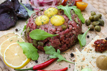 Beef tartare with quail eggs, capers and various appetizers