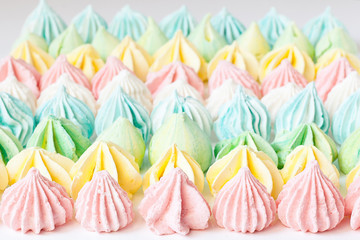 Colored meringues on white backround. Sevective focus