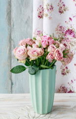 Bouquet of pink roses in ceramic vase.