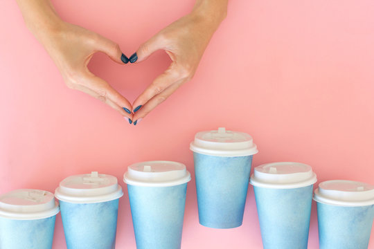 Two Hands Making Heart Between Many Paper Cups Of Coffee To Go. Coffee, Love Concept. Flat Lay Style.