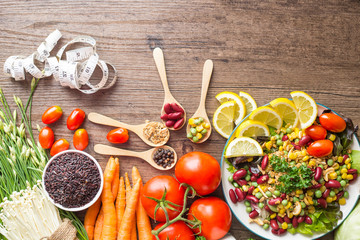 Healthy food background ,fruits and vegetables with salad bowl and measuring tape  on wooden table.