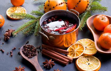 Mulled wine in a pot with spices and citrus fruits.
