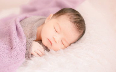 New born baby lying on a soft blanket. Cute  new born baby in natural motion.