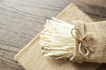 Gold needle mushroom or enoki mushroom on the wooden background.