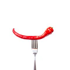 Red bitter chili pepper on the fork on white isolated background. Creative Food concept.