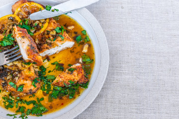 Chicken with lemon in honey sauce on a plate, top view, copy space