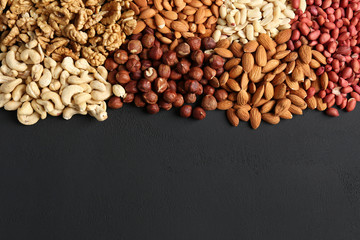 heaps of different nuts on a dark table