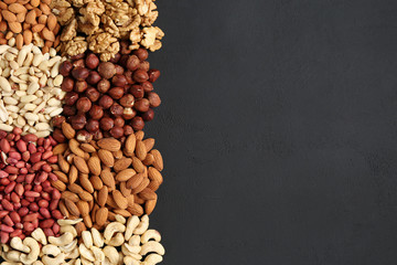 heaps of different nuts on a dark table