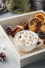 Fototapeta na wymiar Hot chocolate with marshmallow cinnamon sticks, anise, nuts on wooden tray, Christmas concept