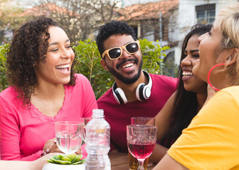 Multicultural students partying together at cafe bar outdoor. Spring, warm, togetherness, lifestyle, diversity concept.