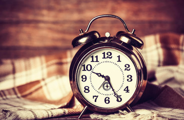 Alarm clock and scarf. Photo in retro color style.