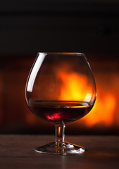 glass of cognac in front of fireplace