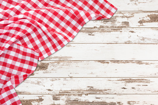Vintage white wooden table with red checkered tablecloth. Top view mockup.
