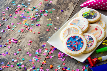 New Year cookies and confetti on wooden table. Copyspace