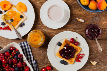 Breakfast. Toasts with cherry or peach jam and fresh fruit.