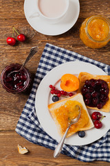 Breakfast. Toasts with cherry or peach jam and fresh fruit.