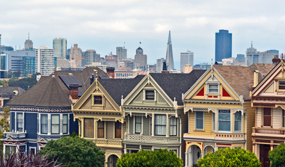 San Francisco, CA / USA - August 2017: The Painted Ladies at Alamo Square with the Financial District in the distance