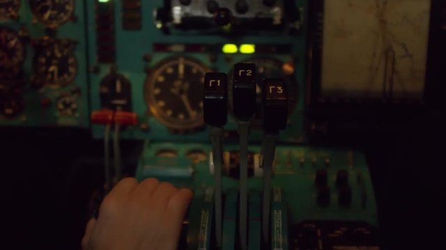 Close up shot of hands of unrecognizable aircraft captain operating throttle in cockpit of airplane