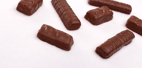 White sugar background, candy bars in sugar