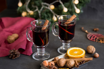 Mulled wine in glass with spices at dark background