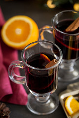 Mulled wine in glass with spices at dark background