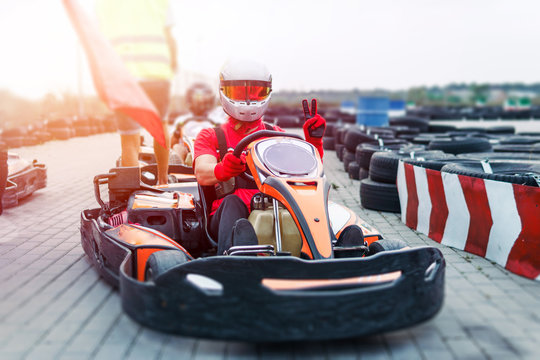 Go-Kart racing car on the track in action, championship, active sports, extreme fun, the driver keeps his hands on the wheel. driver protective gear. day, karting