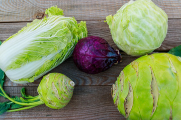 Several kinds of cabbage on rustic wooden table. Top view