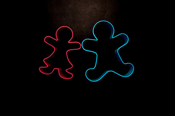 colored gingerbread man shaped food on black backround