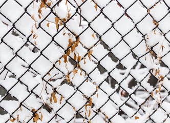 Snow and ice on a metal grid as a background
