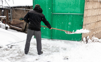 The man was shoveling snow in the winter