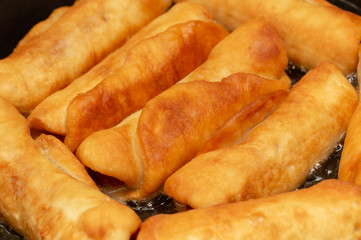 Sausages in dough fried in a pan